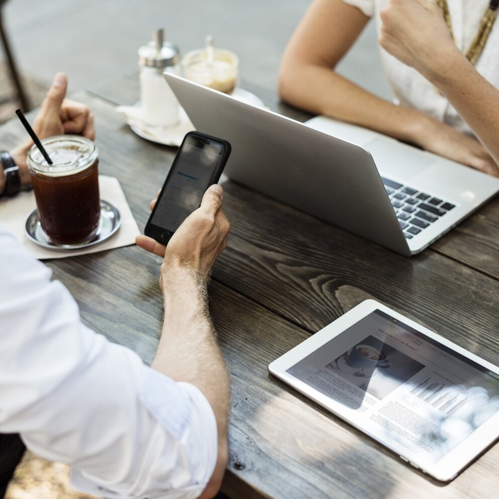 Personen die an einem Tisch sitzen und Networken